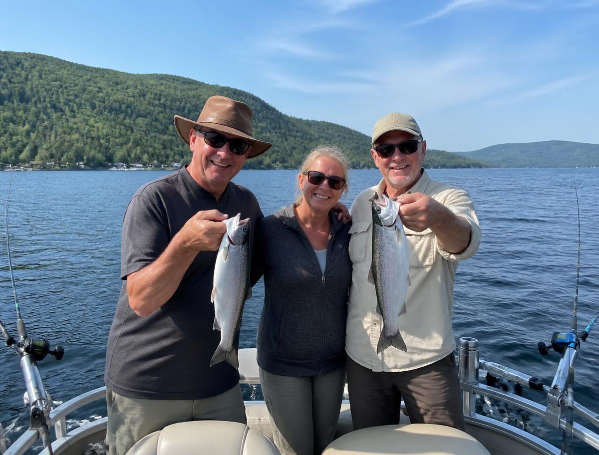 Groupe de trois pêcheurs sur un pontoon au lac Archambault montrant leurs ouananiches de 16 à 20 pouces