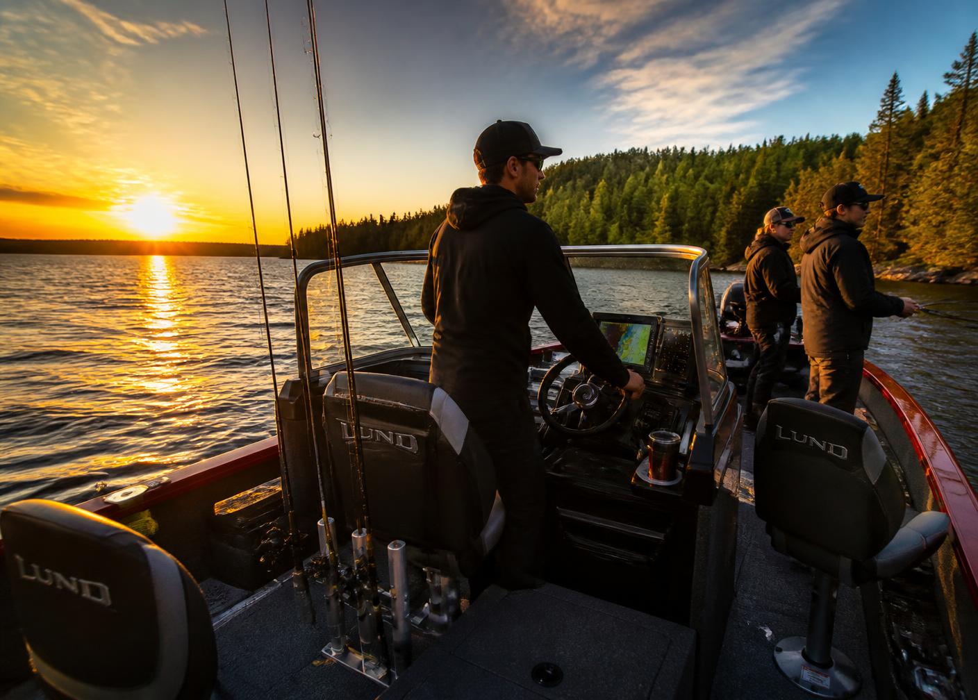Bateau de pêche guidé tout inclus sur un grand lac du Québec au lever du soleil, guide au poste de pilotage et pêcheurs aux cannes